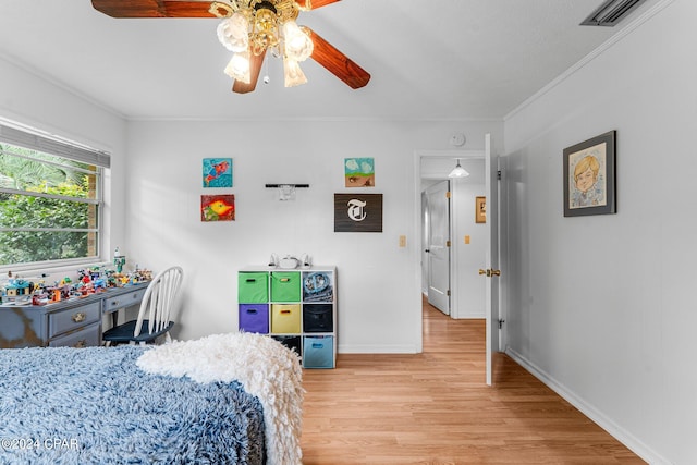 bedroom with crown molding, light hardwood / wood-style floors, and ceiling fan