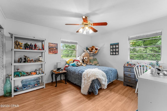 bedroom featuring crown molding, light hardwood / wood-style floors, and ceiling fan