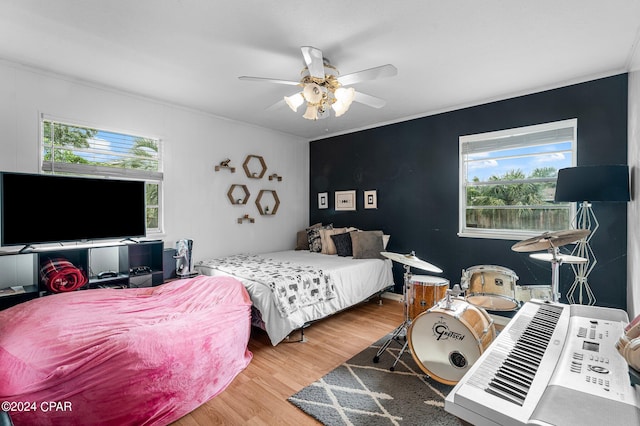 bedroom featuring wood-type flooring, multiple windows, and ceiling fan