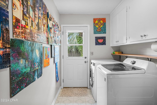 washroom with cabinets and washing machine and dryer