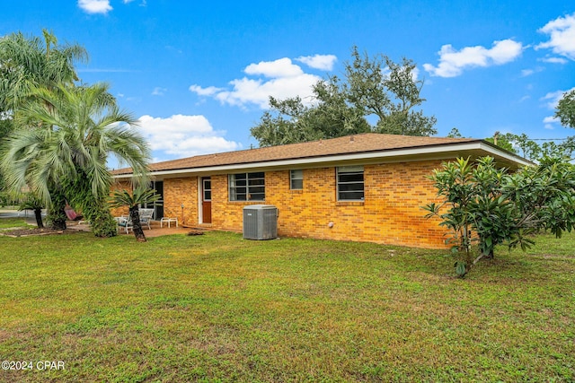 back of property featuring a lawn, a patio, and cooling unit