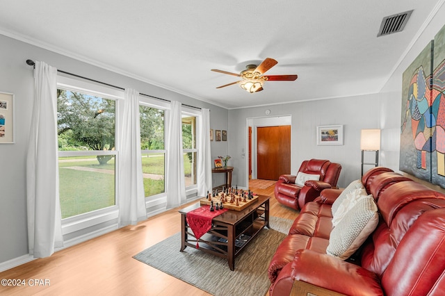 living room with light hardwood / wood-style floors, ceiling fan, and crown molding