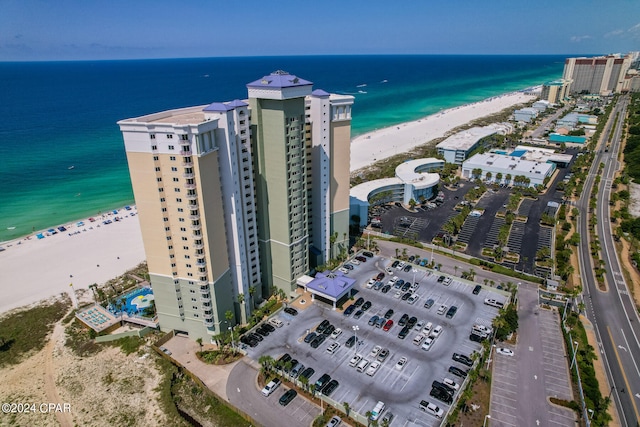 birds eye view of property with a water view and a beach view