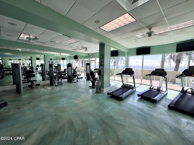 exercise room featuring ceiling fan and a drop ceiling