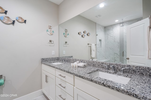 bathroom featuring a tile shower, tile patterned flooring, and vanity