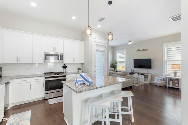 kitchen featuring appliances with stainless steel finishes, white cabinetry, and dark hardwood / wood-style floors