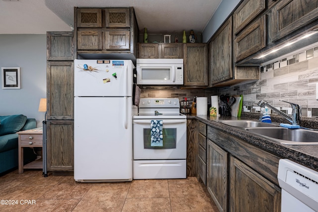 kitchen with backsplash, white appliances, light tile patterned floors, dark brown cabinets, and sink