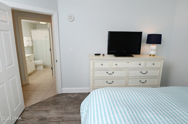 bedroom featuring dark tile patterned floors and ensuite bath