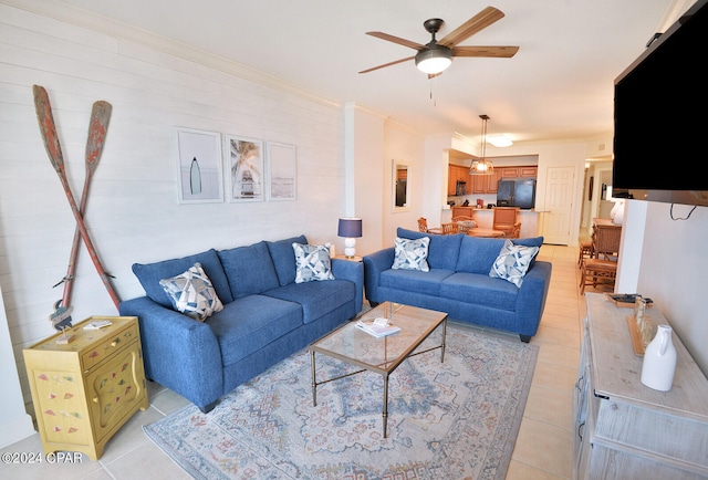 living room with ceiling fan, ornamental molding, and light tile patterned floors