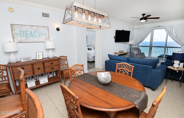 tiled dining space featuring ornamental molding and ceiling fan