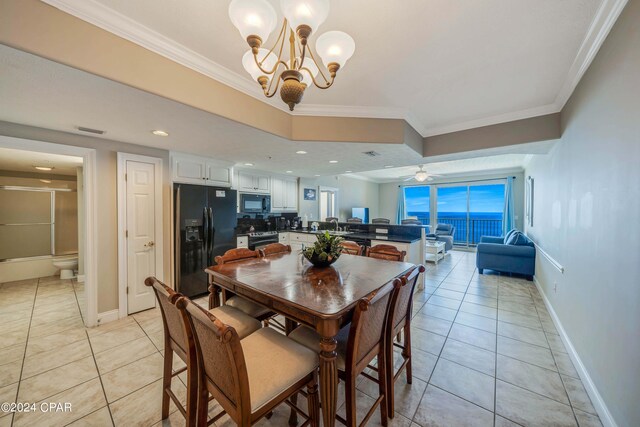 tiled dining area featuring sink, ceiling fan with notable chandelier, and ornamental molding