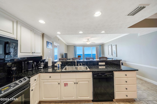 kitchen featuring dark stone countertops, kitchen peninsula, sink, and black appliances