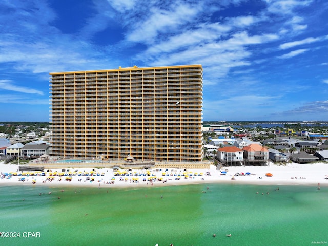 view of property with a water view and a beach view