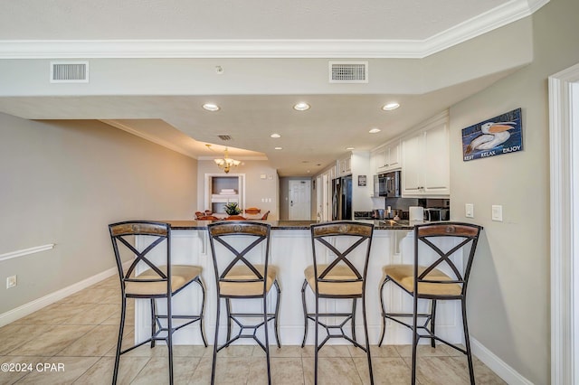 kitchen with white cabinetry, ornamental molding, kitchen peninsula, and black appliances