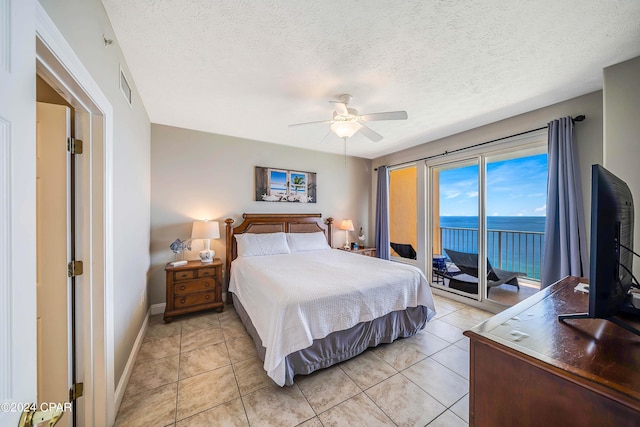 tiled bedroom with ceiling fan, access to exterior, and a textured ceiling