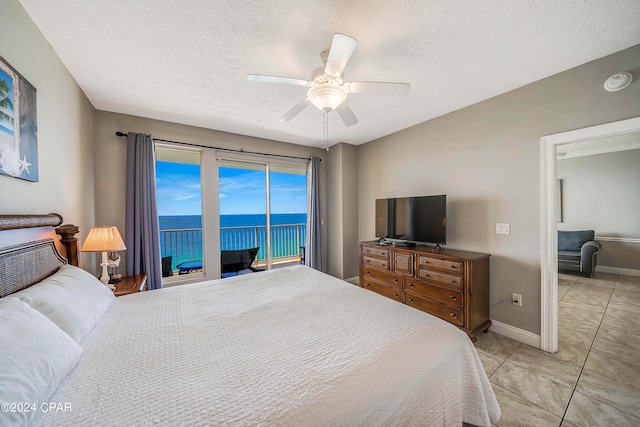 bedroom featuring access to outside, a textured ceiling, ceiling fan, and light tile patterned floors