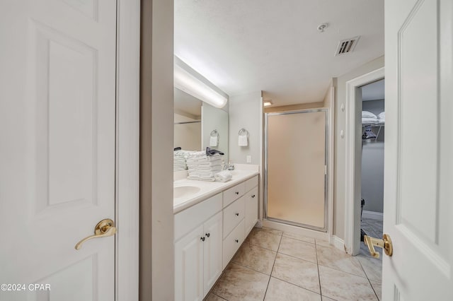 bathroom featuring walk in shower, vanity, and tile patterned flooring