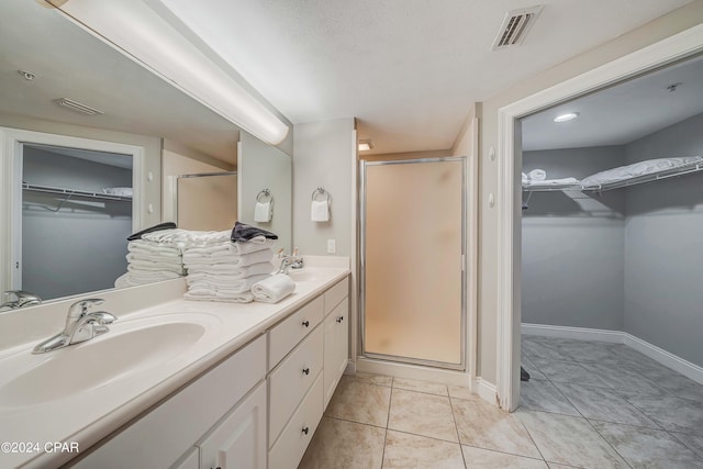 bathroom featuring tile patterned floors, an enclosed shower, vanity, and a textured ceiling