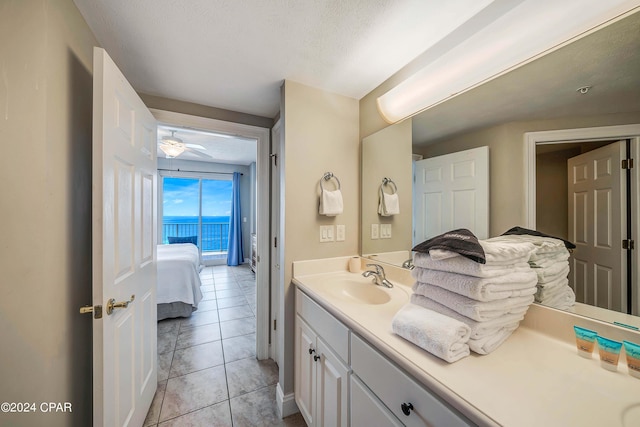 bathroom with ceiling fan, vanity, tile patterned flooring, and a textured ceiling