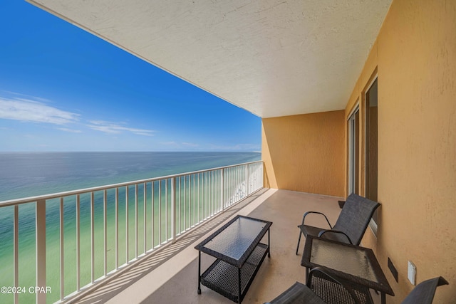 balcony featuring a water view and a view of the beach