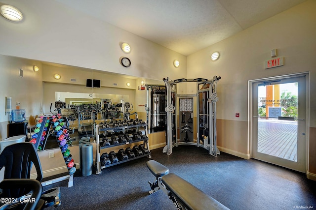 workout area featuring vaulted ceiling and a textured ceiling