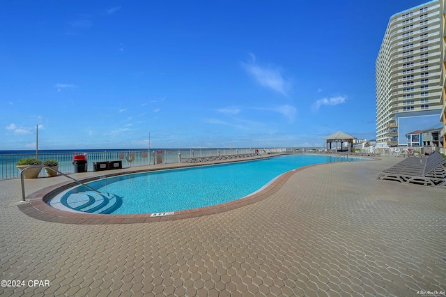 view of swimming pool featuring a gazebo and a water view