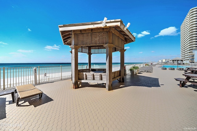 view of home's community with a water view, a beach view, and a gazebo