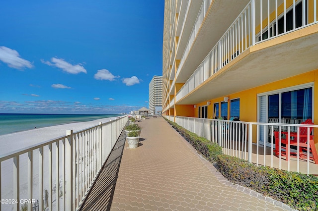 view of property's community with a water view and a beach view