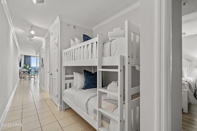 bedroom with tile patterned flooring, baseboards, and ornamental molding