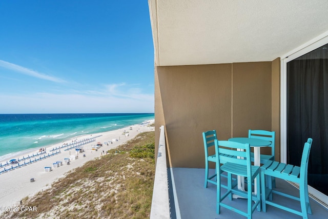 balcony featuring a view of the beach and a water view