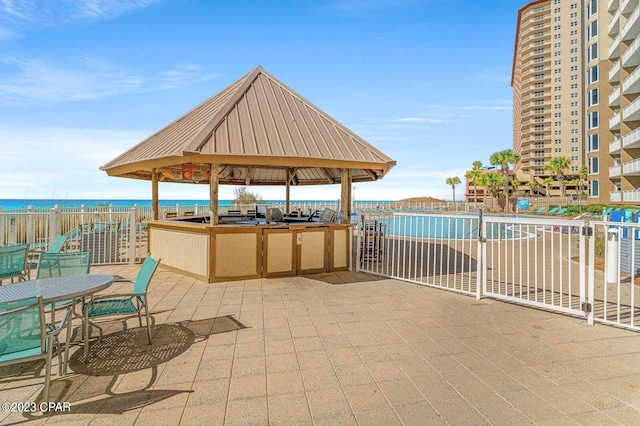 view of patio / terrace with a gazebo, a water view, and fence