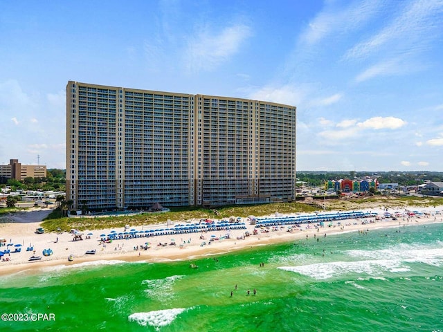 view of building exterior with a water view, a view of city, and a view of the beach