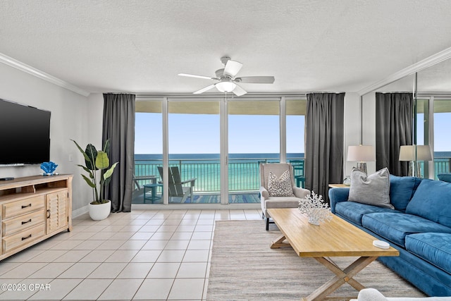 living area featuring a water view, a ceiling fan, floor to ceiling windows, crown molding, and light tile patterned floors