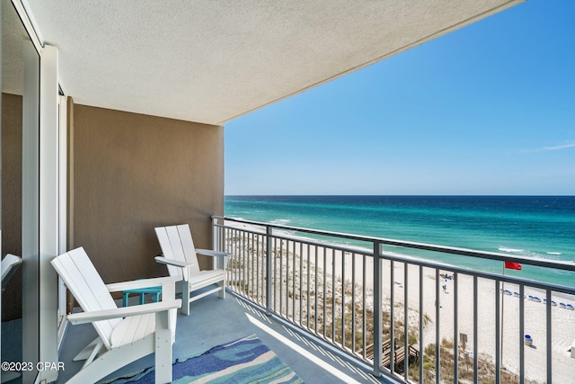 balcony with a water view and a beach view