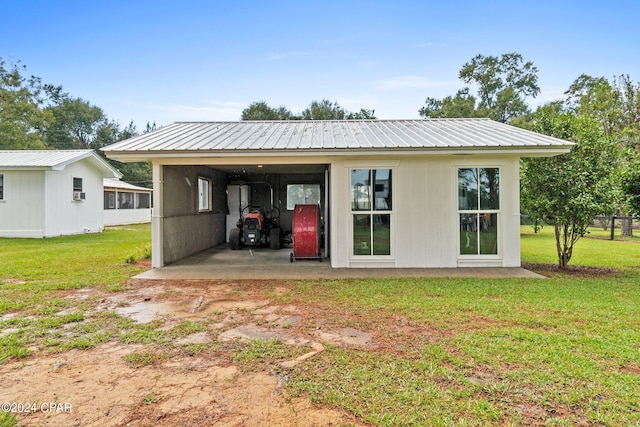 rear view of property with a yard and a carport