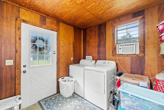 laundry area featuring wooden ceiling, wood walls, and independent washer and dryer