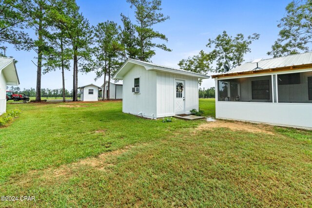 view of yard featuring a storage shed, cooling unit, and a sunroom