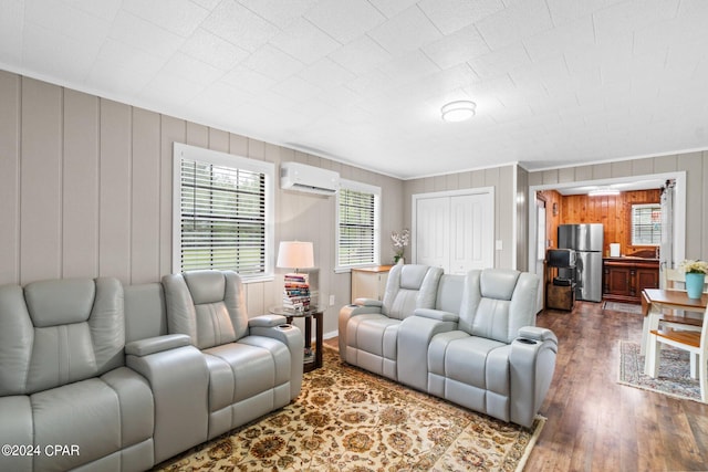 living room with ornamental molding, wood walls, a wall unit AC, and hardwood / wood-style floors