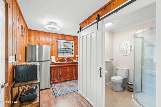 bathroom with an enclosed shower, wood walls, hardwood / wood-style floors, vanity, and toilet