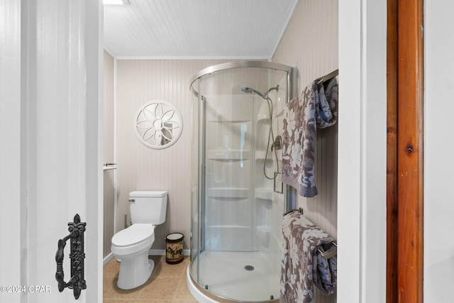 bathroom with crown molding, tile patterned flooring, a shower with door, and toilet