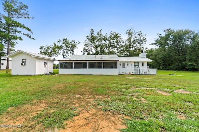 back of house featuring a lawn and a sunroom