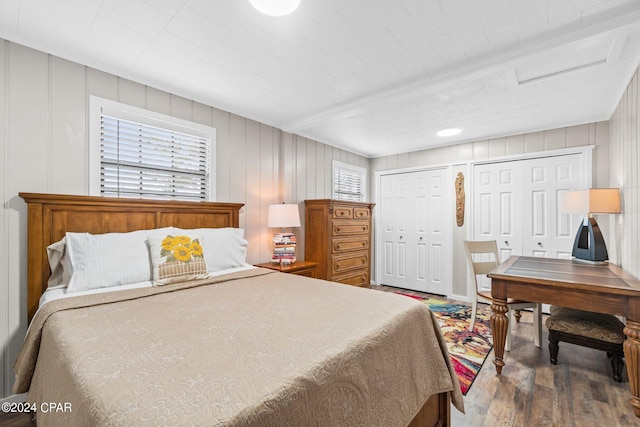 bedroom with multiple closets and hardwood / wood-style floors