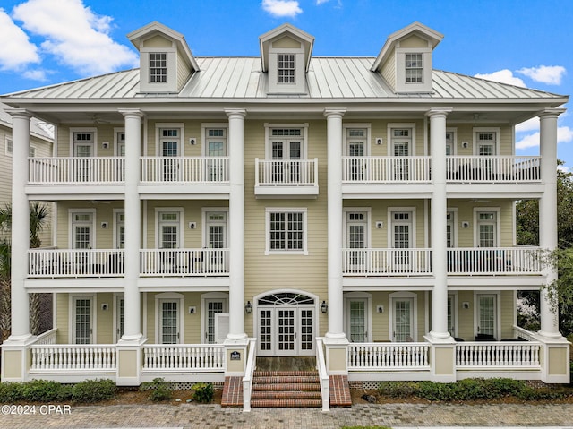 greek revival inspired property featuring a balcony and french doors