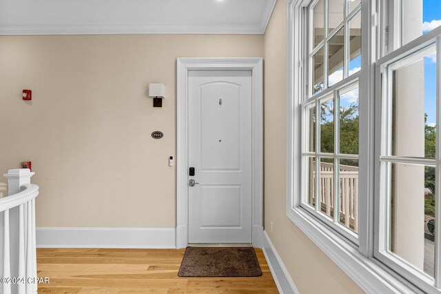 entryway with crown molding and hardwood / wood-style floors