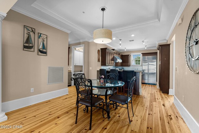 dining space with crown molding and light hardwood / wood-style floors