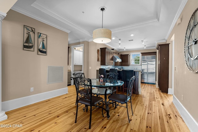 dining area featuring light wood finished floors, visible vents, and ornamental molding