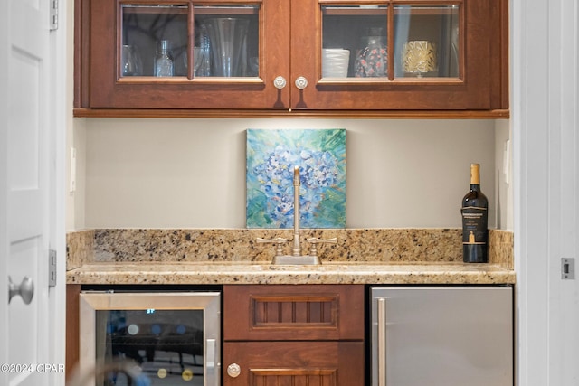 bar with stainless steel fridge, wine cooler, and light stone counters