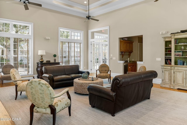 living room with a towering ceiling, ceiling fan, and a wealth of natural light