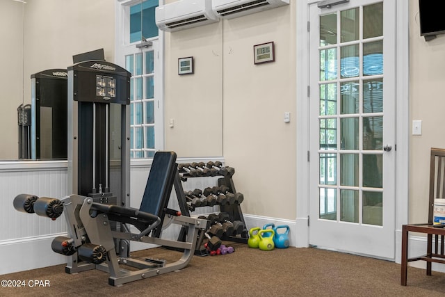 exercise room with carpet floors and a wall mounted AC