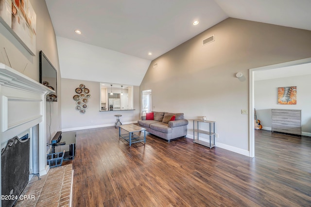 living room with a fireplace, dark hardwood / wood-style flooring, and high vaulted ceiling